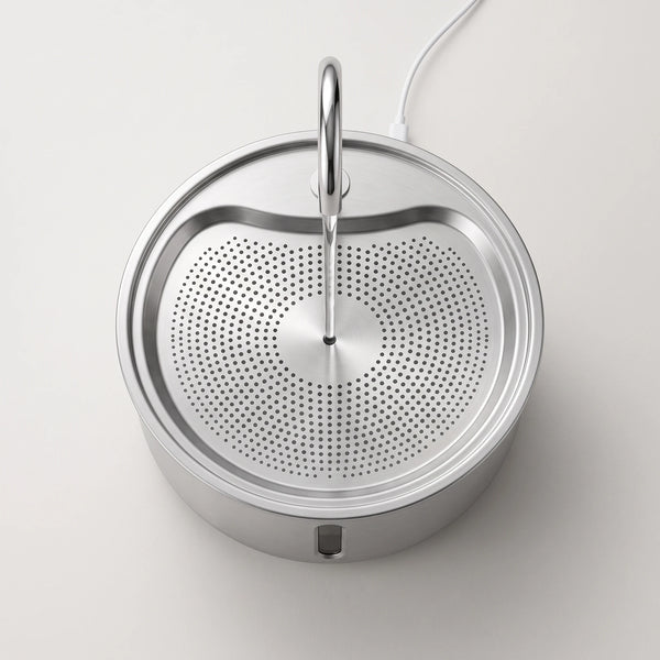 The fountain seen from directly above, three concentric rings of brushed steel